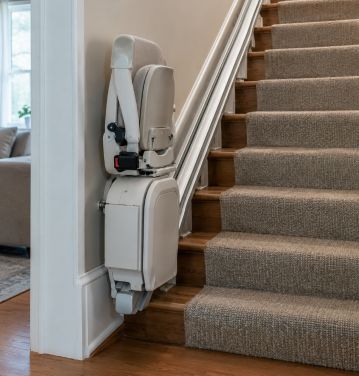 Straight stairlift with a folded seat on a standard indoor staircase in an American home